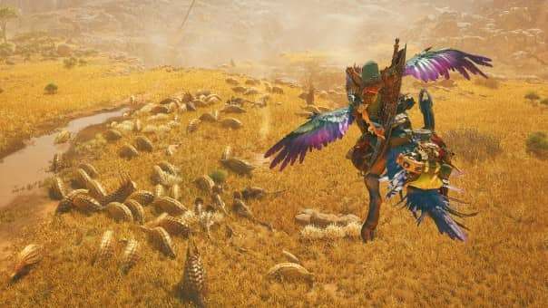 A hunter in the Monster Hunter Wilds review soars on their Seikrat, overlooking a herd of wild animals feeding, showcasing the game's vast world.