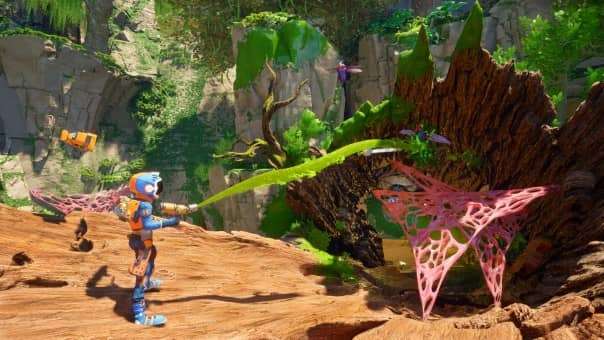 Your character shooting slime to open up a new area in the Revenge of the Savage Planet review, showcasing puzzle mechanics.