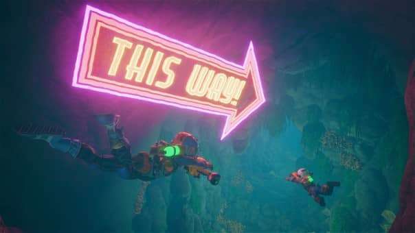 Your character and your mate swimming underwater with a huge neon "This Way" sign in the Revenge of the Savage Planet review.