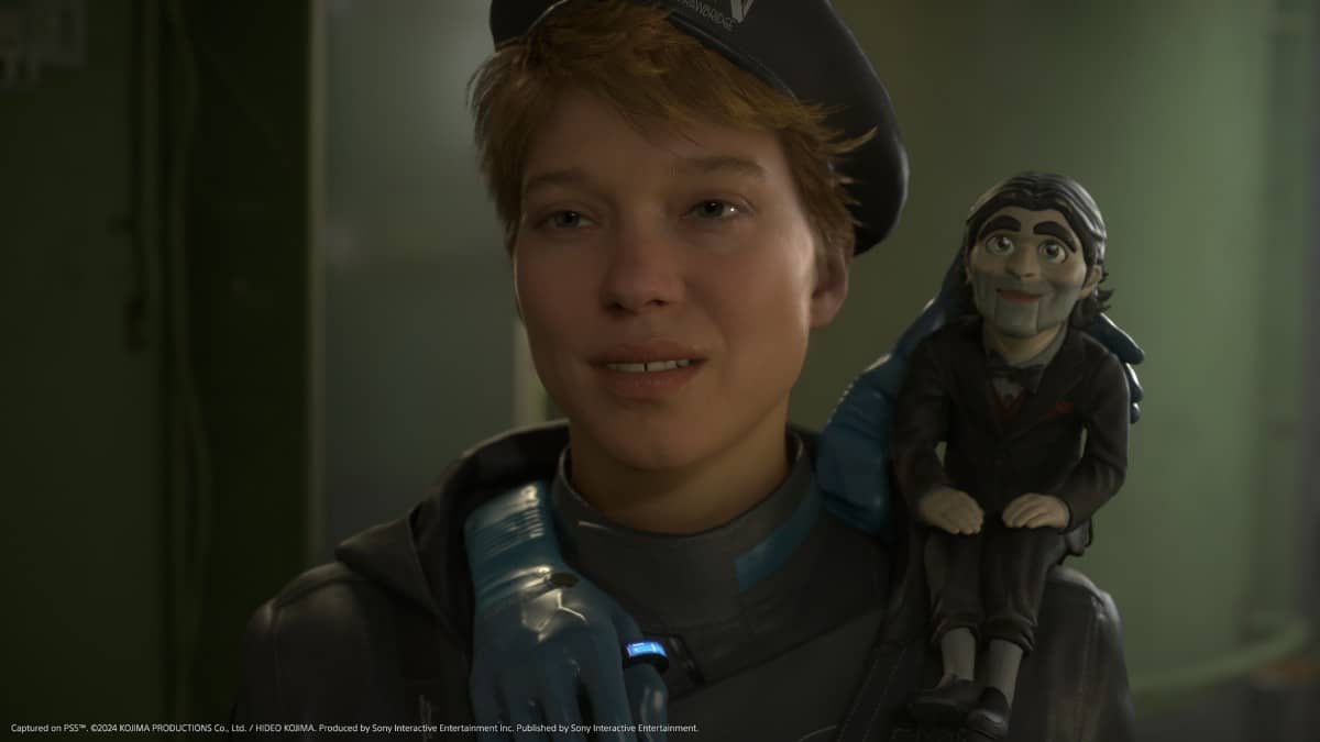 Fragile smiles with Dollman perched on her shoulder in Death Stranding 2: On the Beach, hinting at a quieter moment.