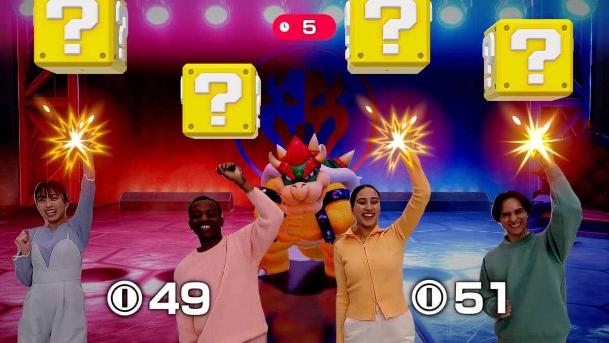 Real players leap and punch upward using Joy-Con motion controls to hit question blocks in Super Mario Party Jamboree – Nintendo Switch 2 Edition + Jamboree TV.
