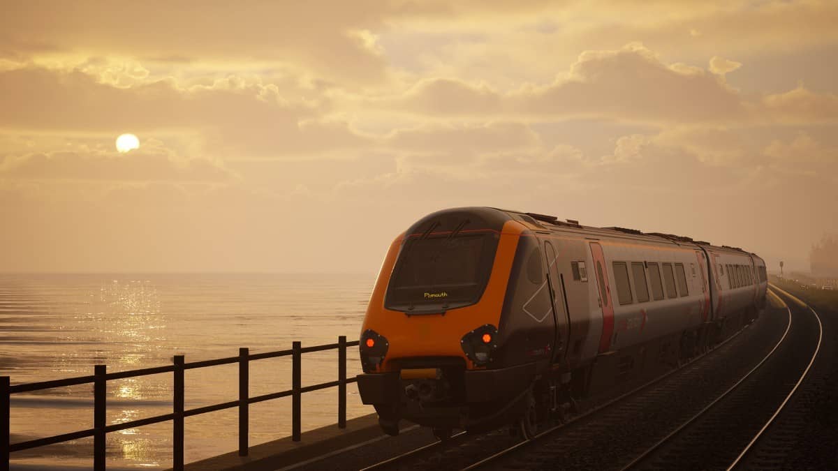 A GWR train glides past the sea along the Plymouth coast in Train Sim World 6, captured during a vivid sunset moment.