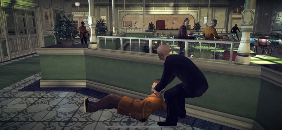 Agent 47 drags a knocked out enemy and hides them behind a desk in Hitman Absolution Android Edition.
