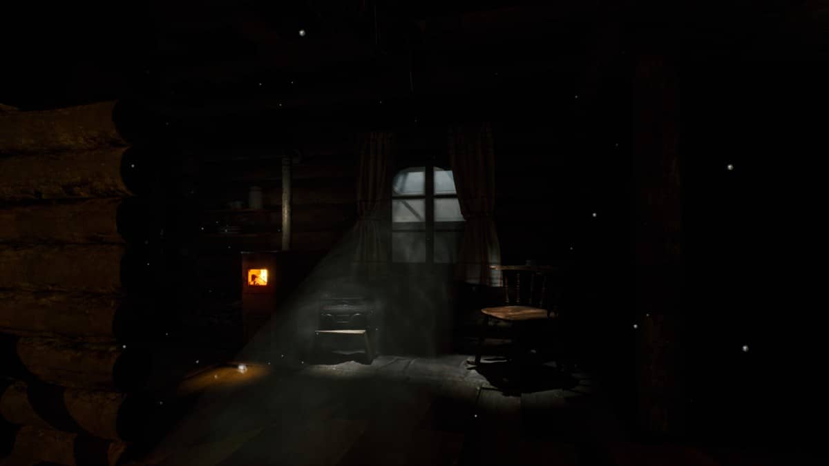 A dimly lit interior in The Cabin Factory where a chair and table barely emerge from the darkness.