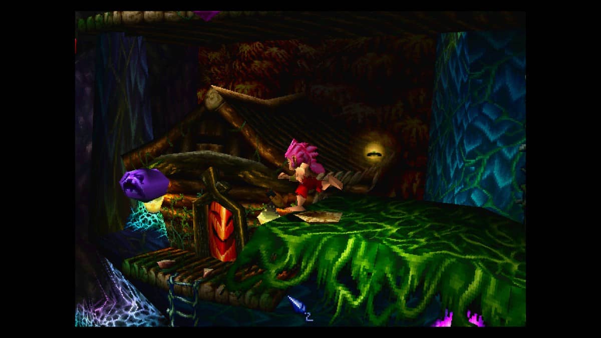 Tomba jumping through a forest area with a big red door in Tomba! 2: The Evil Swine Return Special Edition.