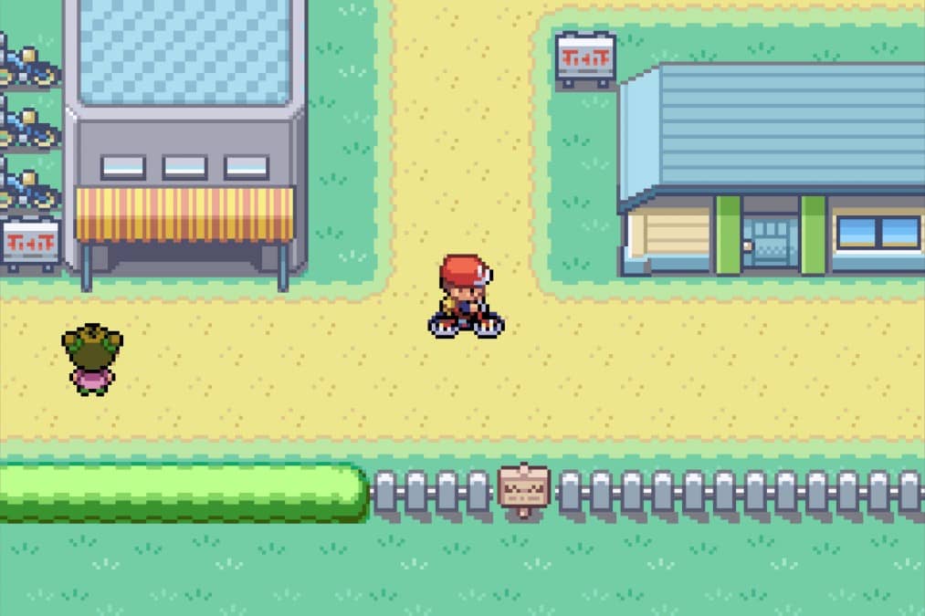 Ash speeds through a Kanto town on his bicycle in Pokémon Fire Red by Gert Lush Gaming.